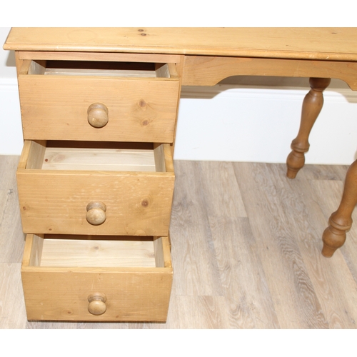 79 - A modern stripped pine desk with 3 drawers, approx 110cm wide x 57cm deep x 77cm tall