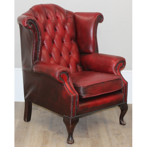 80 - An Ox-Blood red leather Chesterfield style wingback armchair by Wyvern, approx 82cm wide x 100cm tal... 