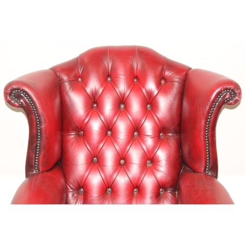 80 - An Ox-Blood red leather Chesterfield style wingback armchair by Wyvern, approx 82cm wide x 100cm tal... 