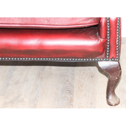 80 - An Ox-Blood red leather Chesterfield style wingback armchair by Wyvern, approx 82cm wide x 100cm tal... 