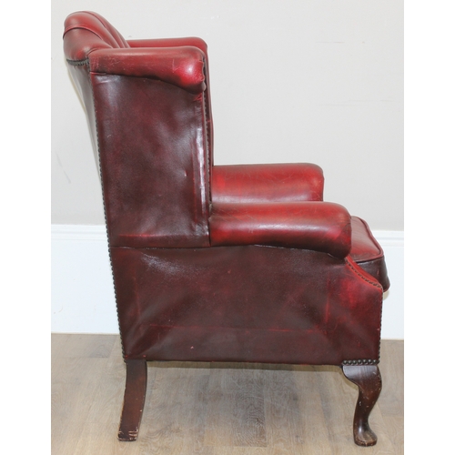 80 - An Ox-Blood red leather Chesterfield style wingback armchair by Wyvern, approx 82cm wide x 100cm tal... 