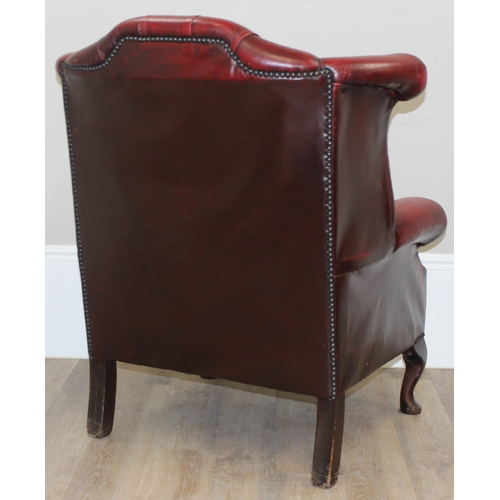 80 - An Ox-Blood red leather Chesterfield style wingback armchair by Wyvern, approx 82cm wide x 100cm tal... 