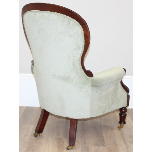 22 - A Victorian style mahogany framed button back nursing chair with brass castors and mint green uphols... 