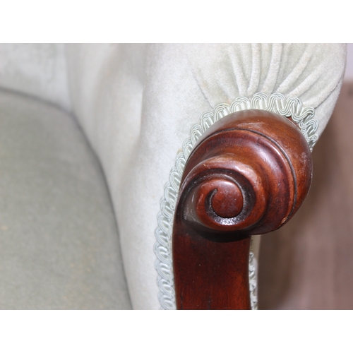 22 - A Victorian style mahogany framed button back nursing chair with brass castors and mint green uphols... 