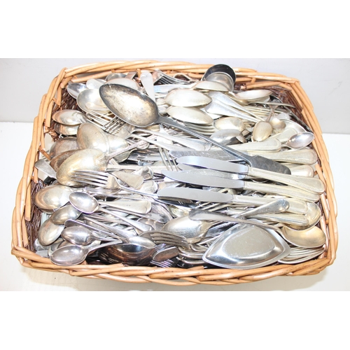 1121 - A huge qty of assorted antique and later silver plate and other cutlery in wicker basket, some sets,... 