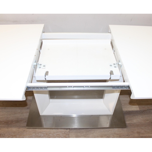 21 - A large modern white extending dining table with brushed steel base, seemingly unmarked, approx 160c... 