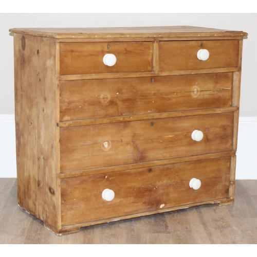 13 - An antique stripped pine 2 over 3 chest of drawers with partial ceramic bun handles, approx 100cm wi... 