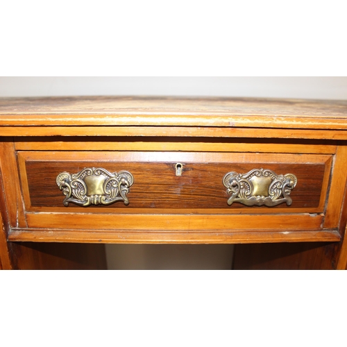 70 - A vintage kneehole desk with 9 drawers and brass handles, distressed leather inset top, approx 122cm... 