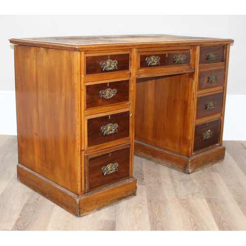 70 - A vintage kneehole desk with 9 drawers and brass handles, distressed leather inset top, approx 122cm... 