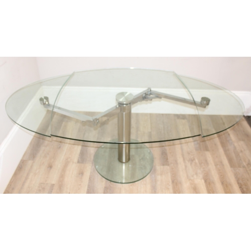 15 - A retro style extending glass table with chrome base and unusual mechanism, seemingly unmarked, appr... 