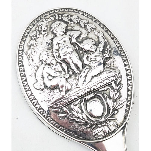 1113 - A superb quality silver backed hand mirror embossed with scenes of cherubs, marked for Birmingham 18... 