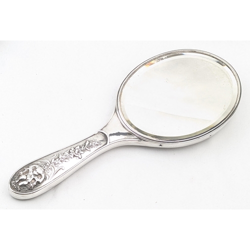 1113 - A superb quality silver backed hand mirror embossed with scenes of cherubs, marked for Birmingham 18... 