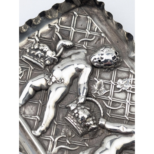 1114 - An antique embossed silver tray decorated with cherubs with baskets, marked for London 1891 by Samue... 