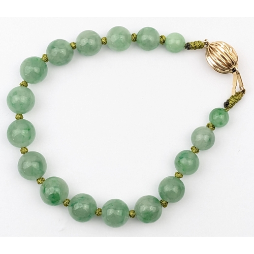 1156 - A vintage green hardstone bracelet believed to be jade with 14ct gold ball clasp, marked and XRF con... 