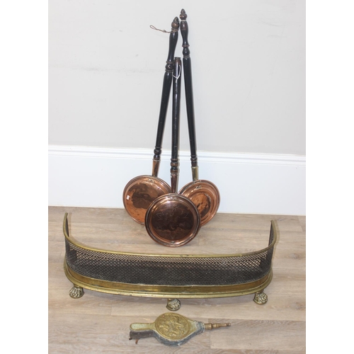 1686 - A vintage brass fire fender with lion paw feet, a pair of brass covered bellows and 3 copper and woo... 