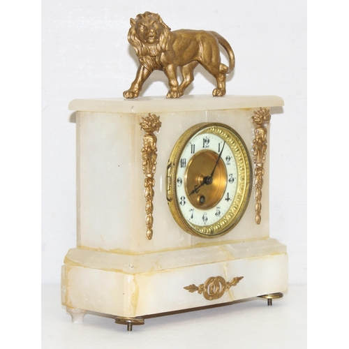 1373 - Antique alabaster clock with mounted gilt-metal lion figurine, with pendulum and key, approx 32 cm H