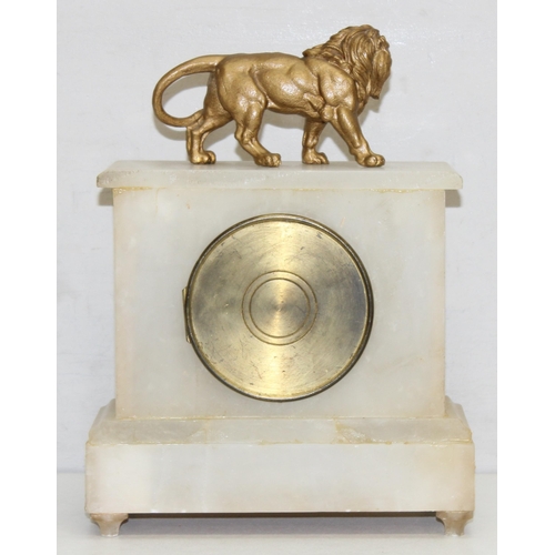 1373 - Antique alabaster clock with mounted gilt-metal lion figurine, with pendulum and key, approx 32 cm H