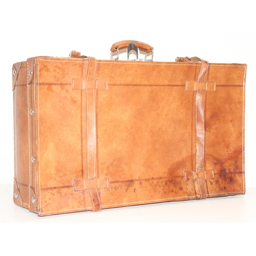 299C - A vintage leather suitcase with chrome plated fittings and various straps, seemingly unbranded, appr... 