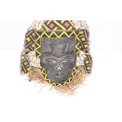 1528 - A vintage African carved wooden mask decorated with beadwork and cowrie shells, possibly a Congolese... 