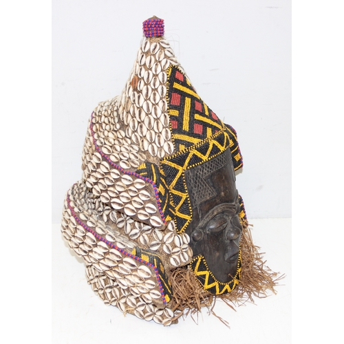 1528 - A vintage African carved wooden mask decorated with beadwork and cowrie shells, possibly a Congolese... 