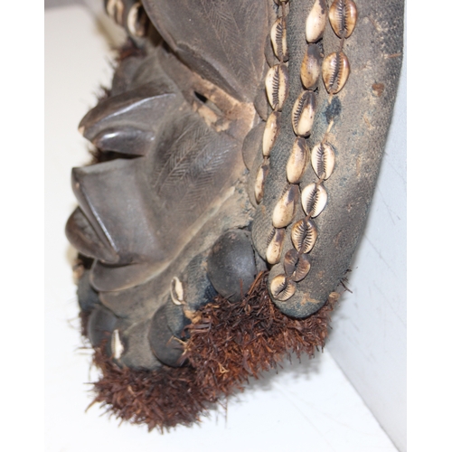 1529 - A vintage carved African mask with raffia beard and shells, believed to be a Congolese Lele mask, ap... 