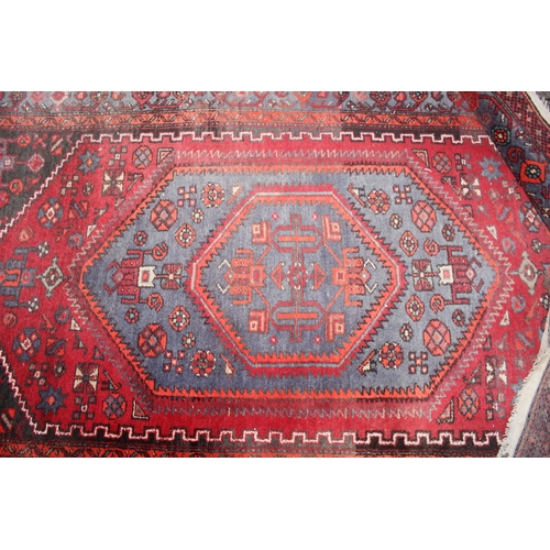 214 - A vintage red ground Iranian or Persian made Hamadan rug, approx 245cm x 142cm