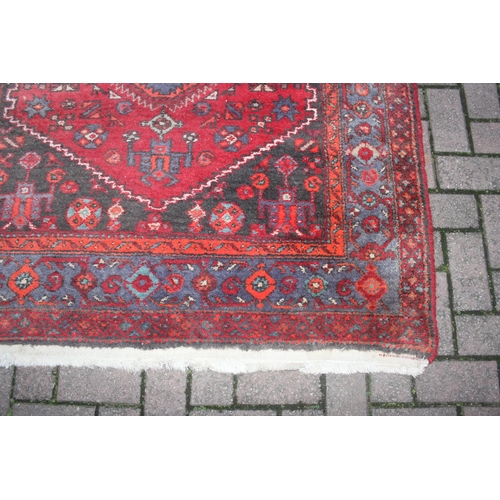 214 - A vintage red ground Iranian or Persian made Hamadan rug, approx 245cm x 142cm