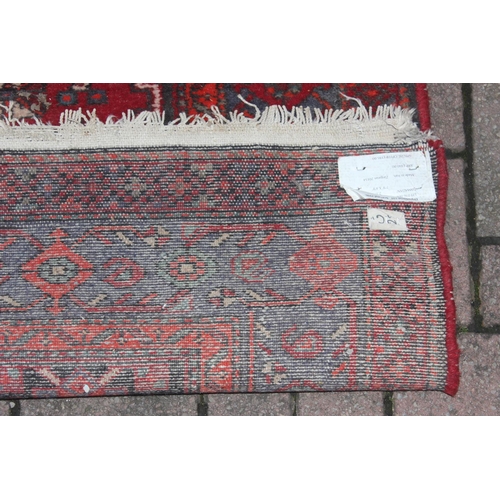 214 - A vintage red ground Iranian or Persian made Hamadan rug, approx 245cm x 142cm