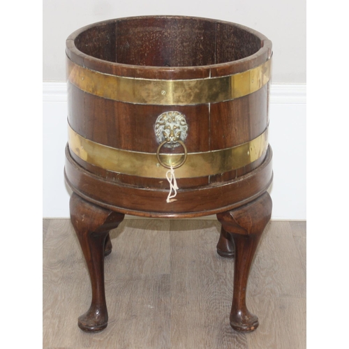 71 - A George III mahogany oval and brass bound wine cooler, circa 1780, now as a jardiniere, with lions ... 