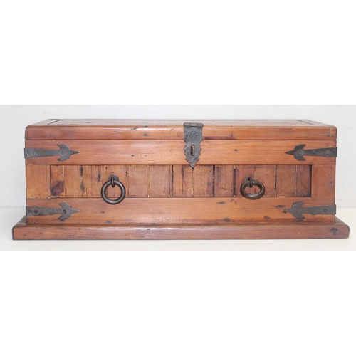 299 - A vintage stained pine trunk with iron fittings, approx 61cm wide