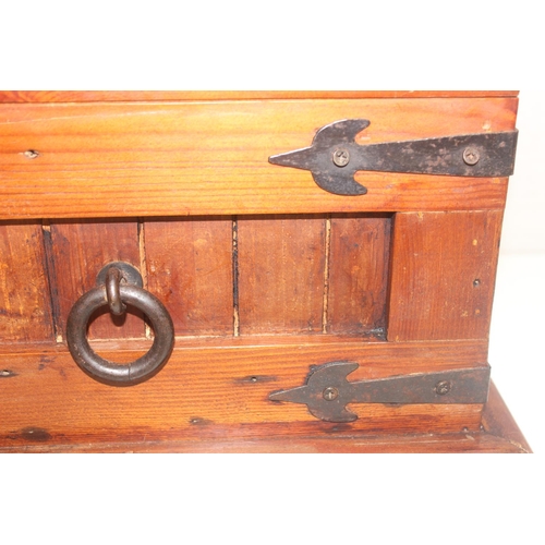 299 - A vintage stained pine trunk with iron fittings, approx 61cm wide