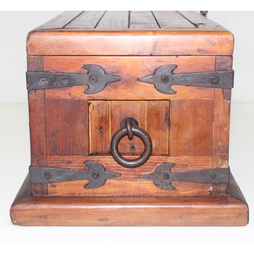 299 - A vintage stained pine trunk with iron fittings, approx 61cm wide