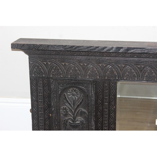 366 - A 19th century Gothic Revival carved oak over-mantel or wall mirror, a projecting cornice over friez... 