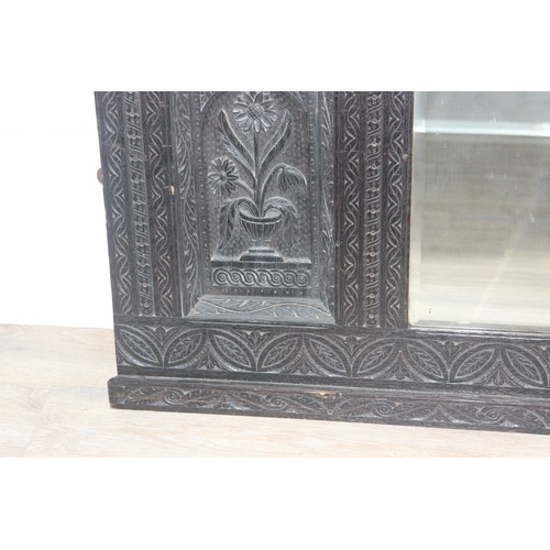 366 - A 19th century Gothic Revival carved oak over-mantel or wall mirror, a projecting cornice over friez... 