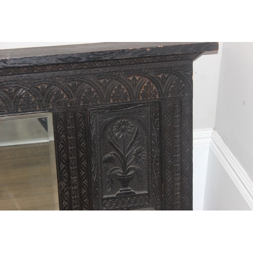 366 - A 19th century Gothic Revival carved oak over-mantel or wall mirror, a projecting cornice over friez... 