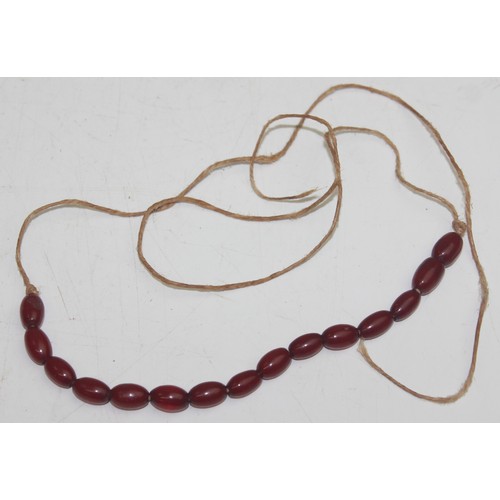 1175 - A qty of assorted loose beads, believed to be cherry amber Bakelite, the largest bead approx 45mm wi... 