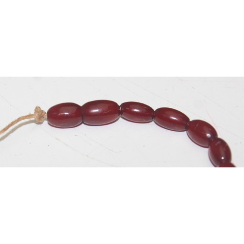 1175 - A qty of assorted loose beads, believed to be cherry amber Bakelite, the largest bead approx 45mm wi... 