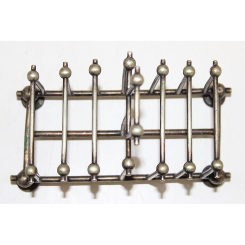 1007 - An antique silver plated 6 slice toast rack in the manner of Christopher Dresser, marked for Benetfi... 