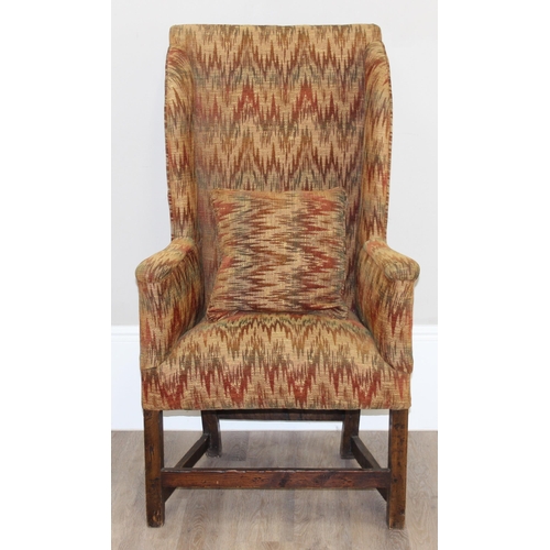 82 - A very unusual antique wing back armchair with patterned gold upholstery, exposed oak legs, believed... 