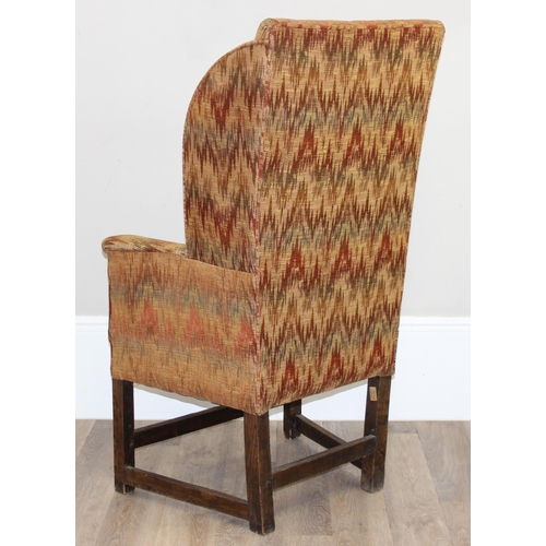 82 - A very unusual antique wing back armchair with patterned gold upholstery, exposed oak legs, believed... 