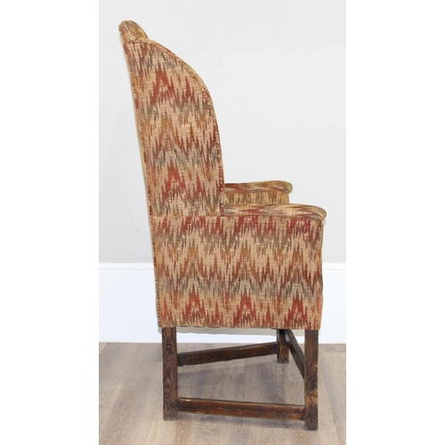 82 - A very unusual antique wing back armchair with patterned gold upholstery, exposed oak legs, believed... 