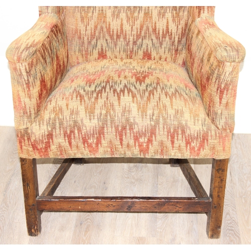 82 - A very unusual antique wing back armchair with patterned gold upholstery, exposed oak legs, believed... 