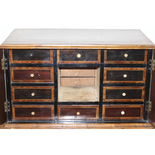 12 - An antique walnut veneered cabinet on stand, believed to be late 17th or early 18th century, the bas... 