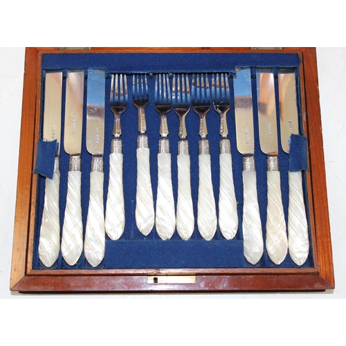 1018 - A boxed set of silver bladed and pronged fruit knives and forks with twist carved mother of pearl ha... 