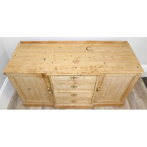 5 - A Victorian pine sideboard with 4 central drawers flanked by 2 cupboards, all with brass fittings, a... 