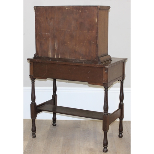 107 - An early 20th century oak desk with bureau top, 2 drawers to base under a fall front cupboard with 2... 