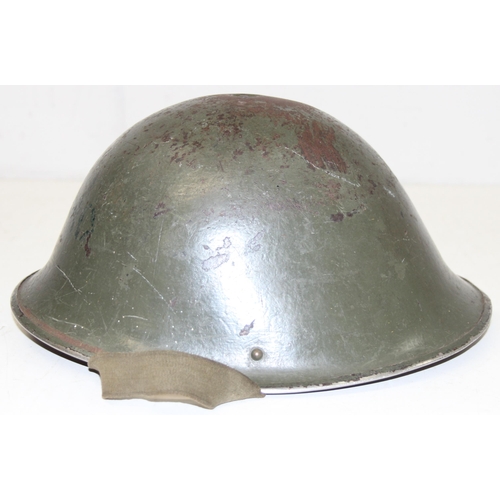 1354 - A vintage green painted British military helmet