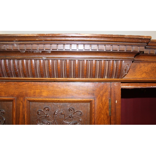 59 - An antique oak and burr wood wardrobe or hall cupboard with carved central panels and 3 doors, the 2... 