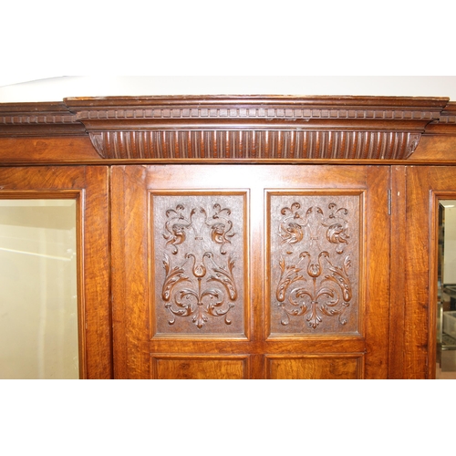 59 - An antique oak and burr wood wardrobe or hall cupboard with carved central panels and 3 doors, the 2... 