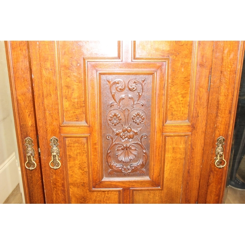 59 - An antique oak and burr wood wardrobe or hall cupboard with carved central panels and 3 doors, the 2... 